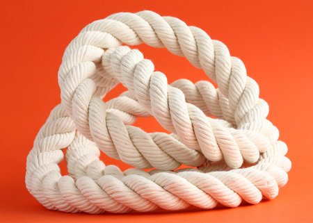 Close-up of a twisted whte cable on red background