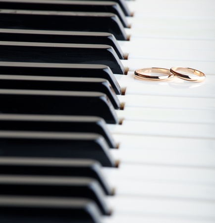 Gold wedding rings on a pianoの写真素材
