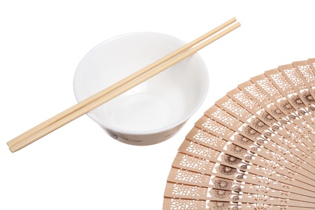Chopsticks on the bowl and wooden fan isolated on whiteの写真素材
