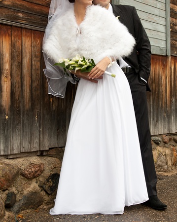 Bride and groom are staying near the wooden wallの写真素材