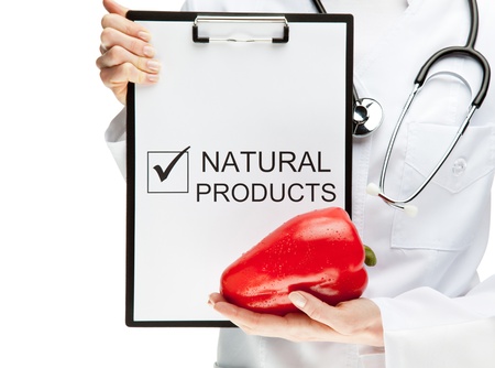 Doctor advising healthy natural products, closeup of doctor's hands holding clipboard with marked checkbox with the word NATURAL PRODUCTS and sweet pepper, healthy eating concept isolated on whiteの写真素材