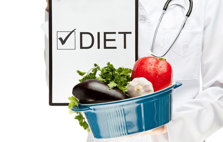 Doctor prescribing diet, closeup of doctor's hands holding clipboard with marked checkbox with the word DIET and brazier with fresh vegetables, dietary concept isolated on whiteの写真素材
