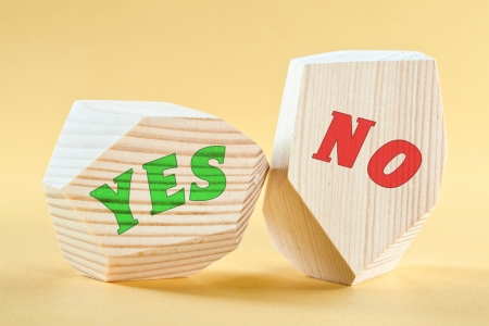  Yes  and  No  written on wooden blocks on yellow backgroundの写真素材