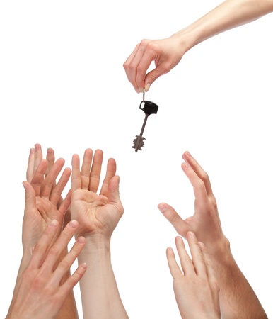 Many hands reaching out for key - concept of winning a house, apartment, etc.; isolated on whiteの写真素材