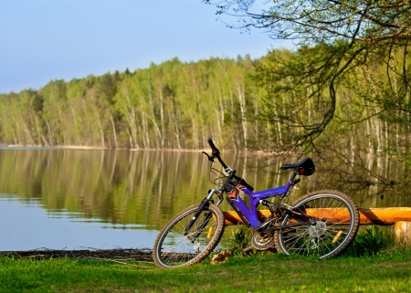 Bicycle on the bank of a beautiful forest lakeの写真素材