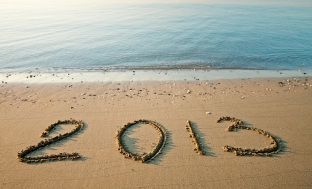 Tranquil morning seashore with 2013 drawn on sandの写真素材