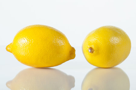 Two fresh lemons on white background