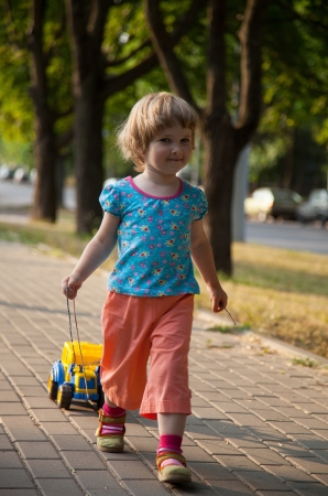 Beautiful little girl playing in summer parkの写真素材