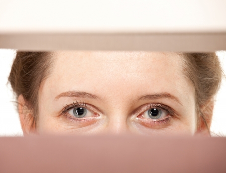 closeup of young woman's eyes watching you closelyの写真素材