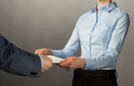 Businessman giving some documents to his secretary, grey backgroundの写真素材