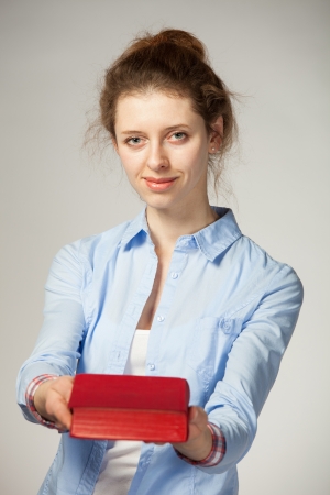 Attractive student showing a book; grey backgroundの写真素材