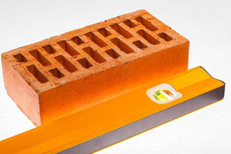 Level and a brick on  white background