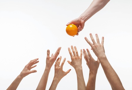 Many hands want to get orange, white backgroundの写真素材