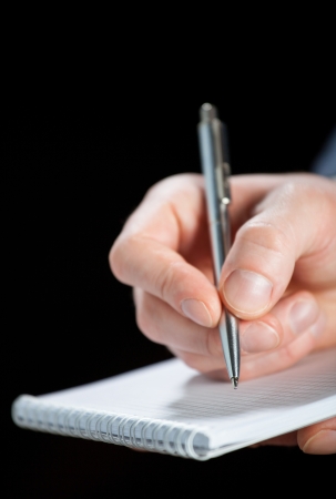 Businessman making notes on the paper, black backgroundの写真素材