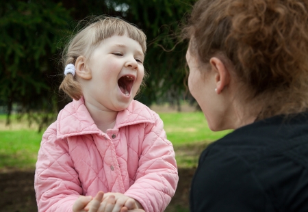 Happy young mother playing with her smiling little daughterの写真素材