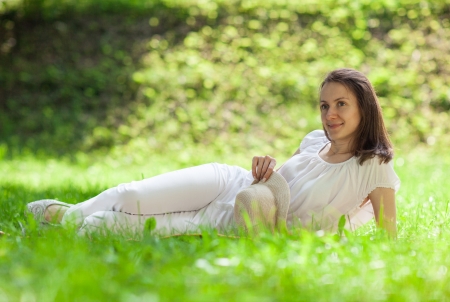 Attractive young woman lying on green grass at summer meadowの写真素材