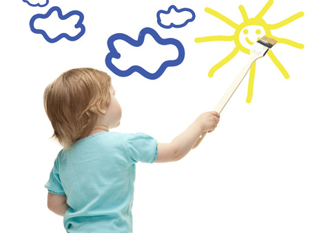 Little child drawing sun with a paintbrushの写真素材