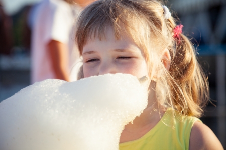 Funny little girl eating cotton candyの写真素材