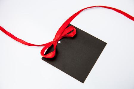 Empty black card with bow on white backgroundの写真素材