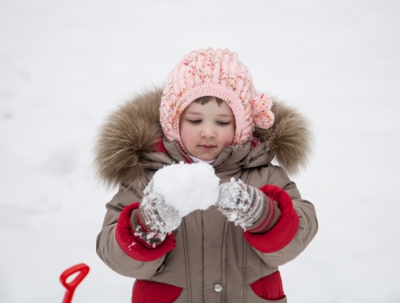 Pretty little girl playing with snowballsの写真素材