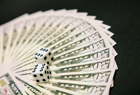 American dollars and dice on a dark tableの写真素材