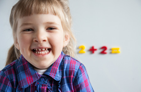 Cheerful little girl learning to count, white background