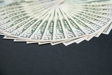 Many dollars banknotes on a dark backgroundの写真素材