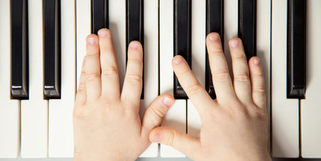 Closeup of child's hands playing the piano