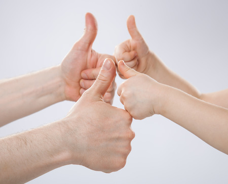 Father and his child showing thumbs up, closeup shot of handsの写真素材
