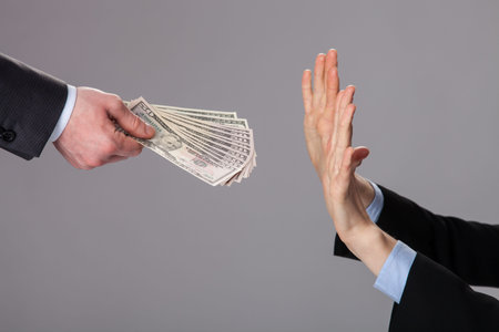 Human hands rejecting an offer of money on grey background