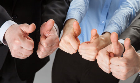 Successful business team showing thumbs up - closeup shot