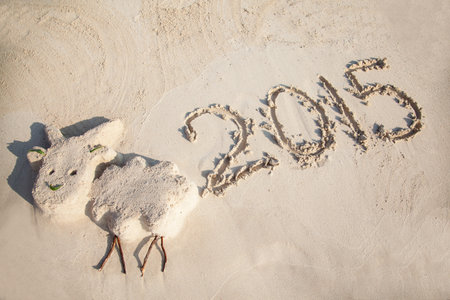 Small funny sculpture of the Goat (symbol of 2015 year) and 2015 number on sandy Cyprus beach