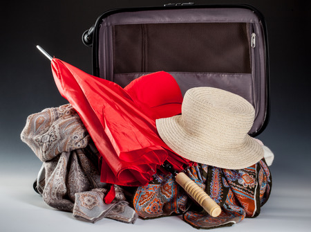 Vacation composition: red umbrella, summer hat and silk kerchiefs in opened suitcaseの写真素材