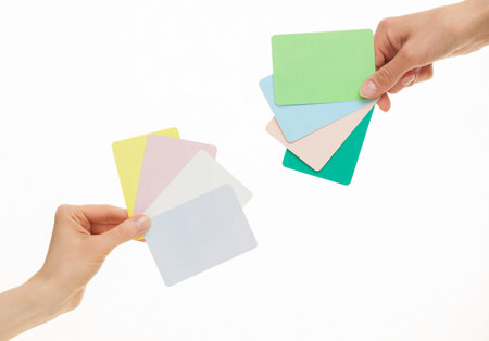 Female hands holding colorful paper cards, white backgroundの写真素材