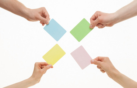 Human hands holding colorful paper cards on white backgroundの写真素材