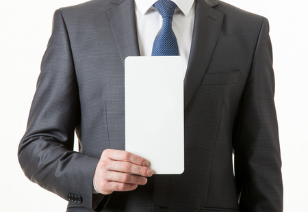 Unrecognizable businessman holding an empty paper card, closeup shotの写真素材