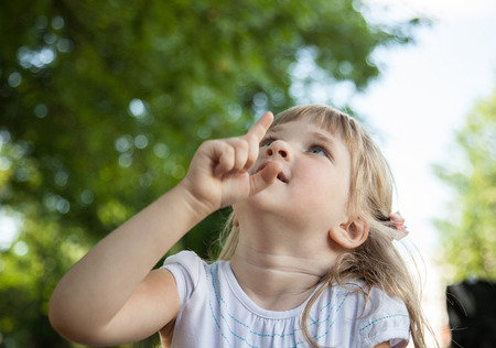 Portrait of charming little girl in a summer parkの写真素材