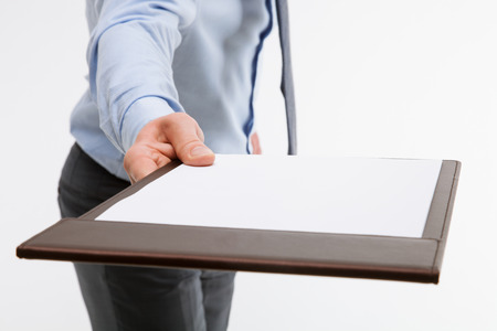 Businessman holding a clipboard with empty sheet of paper, white backgroundの写真素材