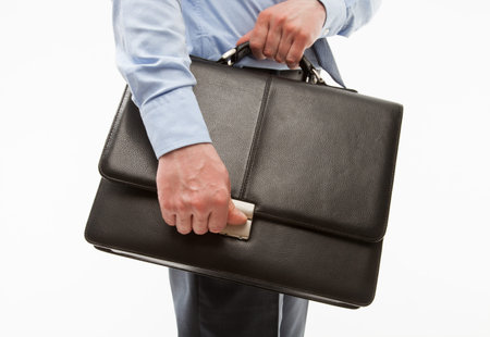 Unrecognizable businessman holding a briefcase, white background