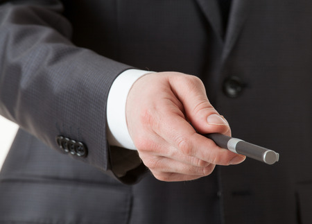 Businessman's hand giving a pen, suit  backgroundの写真素材