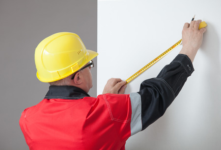 Man in the yellow hard hat determining the distanceの写真素材