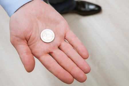 Businessman holding one coin on his palmの写真素材