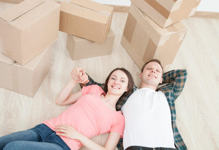 Young couple lying on the floor among cardboard boxes