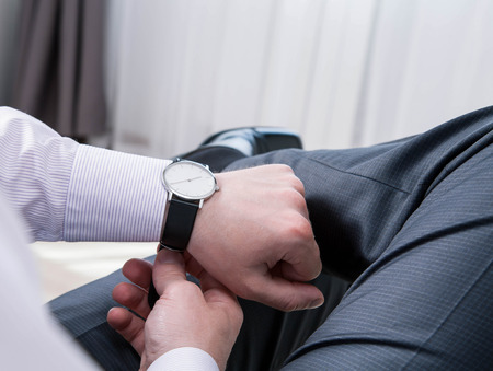 Gentleman clasping a wristlet and sitting in the room, closeup shotの写真素材
