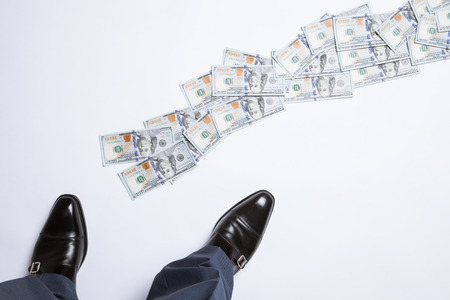 Feet of man in black shoes standing near the money track - closeup shotの写真素材