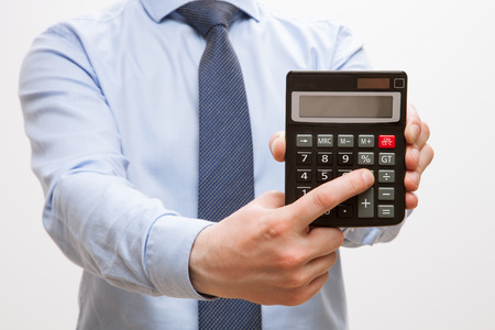 Businessman holding a calculator and counting, white backgroundの写真素材