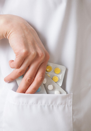 Doctor's hand extracts tablets from a pocket - close-up shotの写真素材