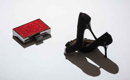 Black shoes and red box on neutral backgroundの写真素材
