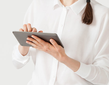 Smiling young businesswoman holding a pad , white background