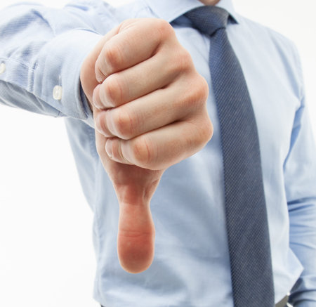 Unrecognizable businessman showing thumb down, white background
